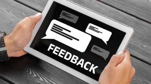 Device shows feedback messages on a screen with chat bubbles in a workspace Stock Photos