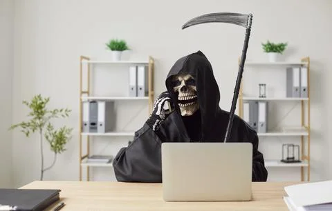 Devil employee sitting in front of laptop in office, talking by phone and Stock Photos