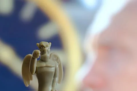 Devil figurine on background of clock face Stock Photos