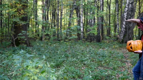 Devil in the forest walks with a pumpkin in his hands. Stock Footage 96891007