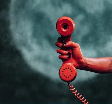 Devil hand with phone handset at midnight Stock Photos