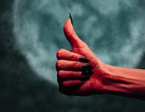 Devil hand with thumb up gesture at midnight Stock Photos
