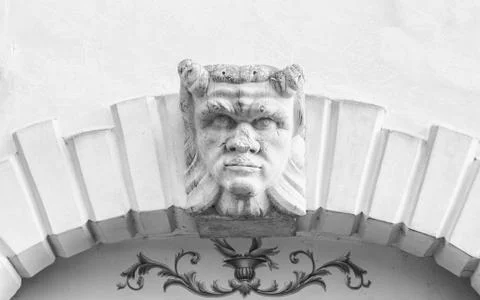 Devil head carved above the stone arch of an Italian villa. Foto stock