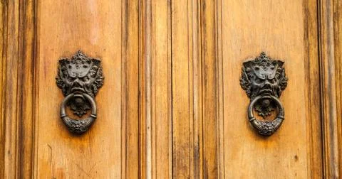 Devil Head Door Knocker Door knoker on an old wodden door in Tuscany - Ita... Stock Photos