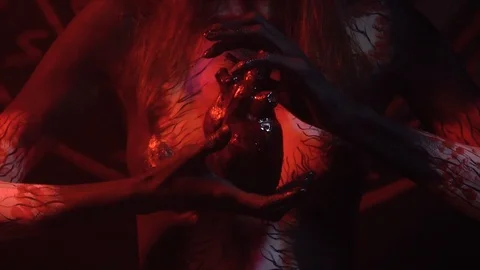 The devil holds in the hands the human heart of his slave, body painting Stock Footage 88614423