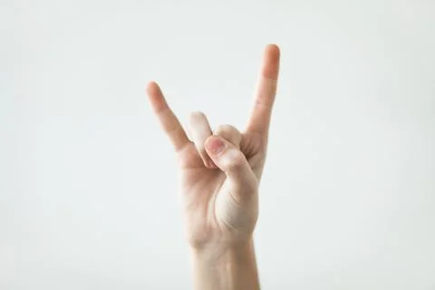 Devil horns gesture with fingers on the light background Stock Photos