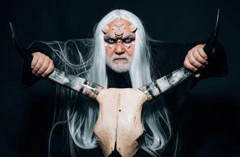 Devil horror concept. Elderly man holding two red horns. Monster with white blue Stock Photos