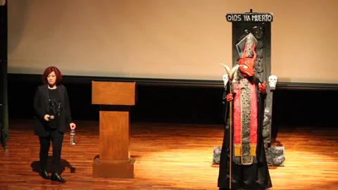 Devil kicks Macabro horror movie fest off and hits a podium mike when walks Stock Footage 282552746
