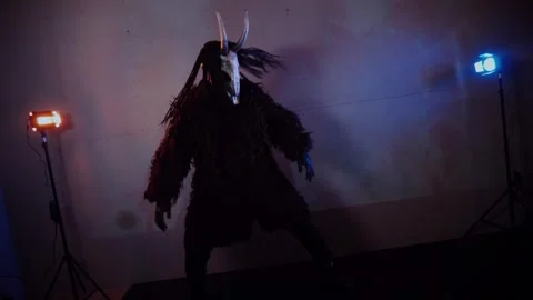 The devil monster dances. A mystical man in a scary mask in a dark studio. Stock Footage 268480937