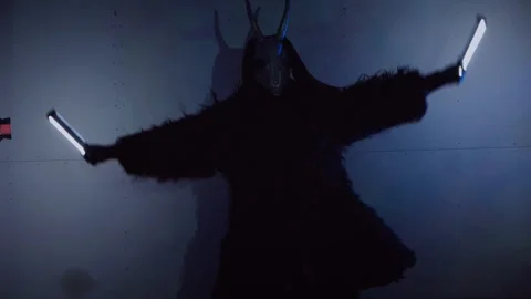 The devil monster dances with RGB sticks in his hands. A man in a scary mask Stock Footage 266919928