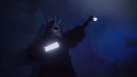 The devil monster dances with RGB sticks in his hands. A man in a scary mask Stock Footage 266919949