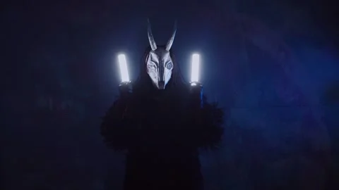 The devil monster dances with RGB sticks in his hands. A man in a scary mask Stock Footage 266919960