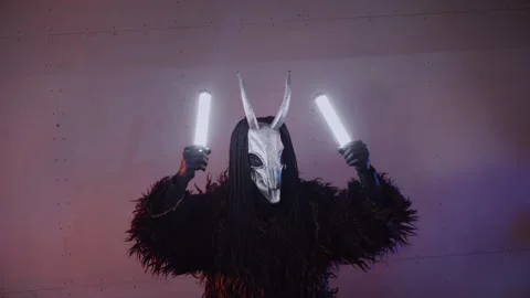 The devil monster dances with RGB sticks in his hands. man in a scary mask Stock Footage 266928028