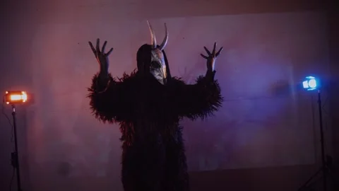 The devil monster dances with RGB sticks in his hands. man in a scary mask Stock Footage 266928031