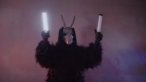 The devil monster dances with RGB sticks in his hands. man in a scary mask Stock Footage 266928054