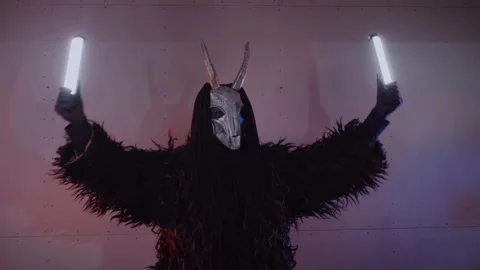 The devil monster dances with RGB sticks in his hands. man in a scary mask Stock Footage 266928243