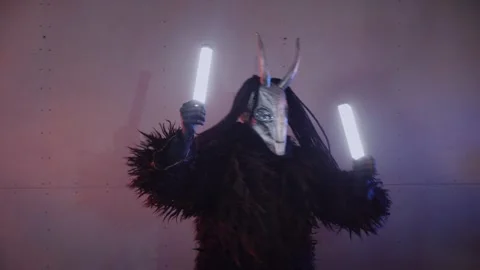 The devil monster dances with RGB sticks in his hands. man in a scary mask Stock Footage 266928244