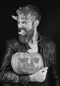 Devil or monster with October decorations. Man wearing scary makeup Stock Photos