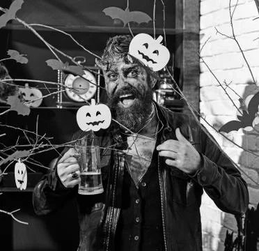 Devil or monster partying. Man wearing scary makeup holds beer Foto stock