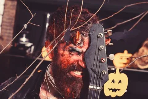 Devil or monster playing instrument. Man wearing scary makeup Foto stock