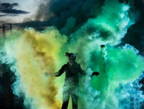 Devil with scary mask surrounded by coloured smoke Foto stock