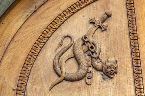 Devil snake symbol. Fantasy magic creature on an old door, 12th Century Abbey Stock-Fotos