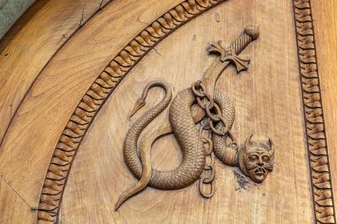 Devil snake symbol. Fantasy magic creature on an old door, 12th Century Ab... Stock Photos