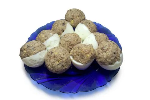 Deviled eggs, arranged in triangle shape, on glass blue plate. isolated on .. Stock Photos