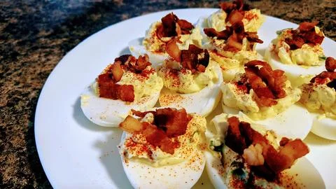 Deviled Eggs with Bacon Garnish on White Plate, Home Cooking Appeal Foto stock