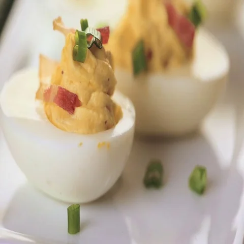 Deviled eggs garnished with green onions and bacon. Video stock 69725369