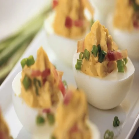 Deviled eggs garnished with green onions and bacon. Video stock 69725533