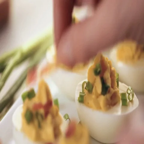 Deviled eggs garnished with green onions and bacon. Video stock 69725591