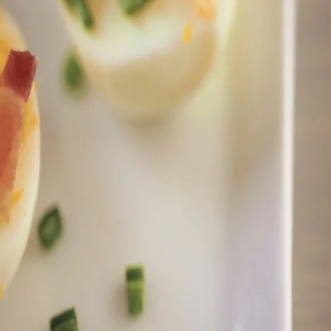 Deviled eggs garnished with green onions and bacon. Video stock 69725948