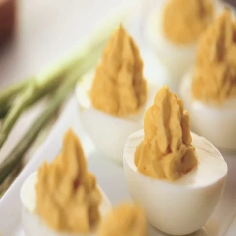 Deviled eggs garnished with green onions and bacon. Video stock 69725957