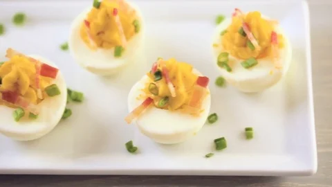 Deviled eggs garnished with green onions and bacon. Video stock 69726276