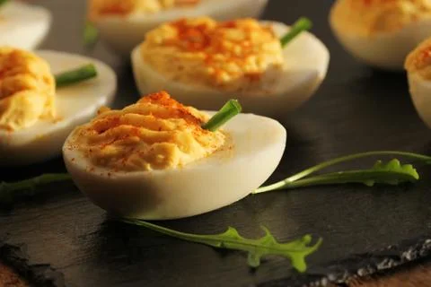 Deviled eggs with red pepper on black background Stock Photos
