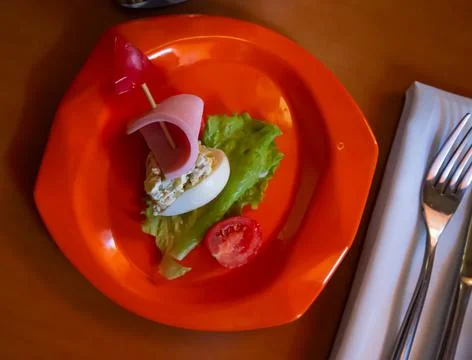 Devilled egg in shape of ship with sausage slice and fresh vegetables Stock Photos