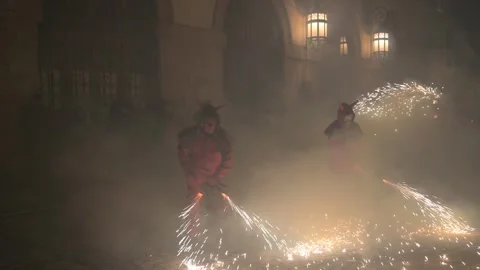 Devils dancing through smoke and sparks in a fiery street performance, Correfoc Video stock 299967793
