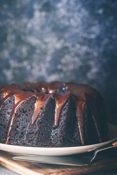 Devil's food cake covered with melted chocolate and a bowl of fresh raspberries Stock Photos