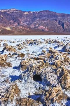 Devil's Golf Course Salt Formations and Rugged Mountains Under Clear Blue Sky Stock Photos