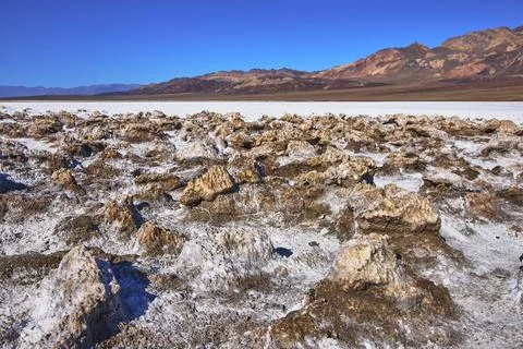 Devil's Golf Course Salt Formations and Desert Mountains Under Clear Blue Sky Foto stock