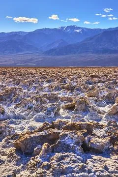 Devil's Golf Course Salt Formations and Distant Mountains Under Blue Sky Stock Photos