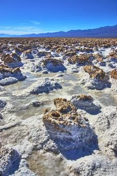 Devil's Golfcourse Salt Formations and Distant Mountains Under Clear Blue Sky Stock Photos