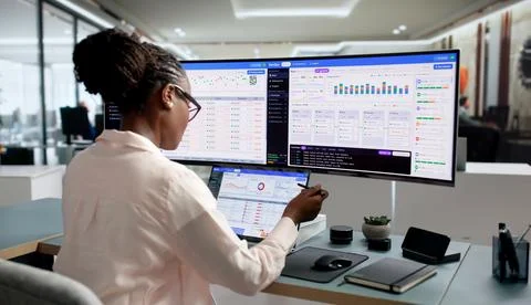 DevOps Engineer Monitors Deployment Pipeline Status Using Laptop At Workstati Stock Photos