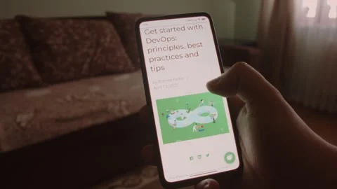 DevOps. Reading information about DevOps on mobile phone screen. Stock Footage 249818889