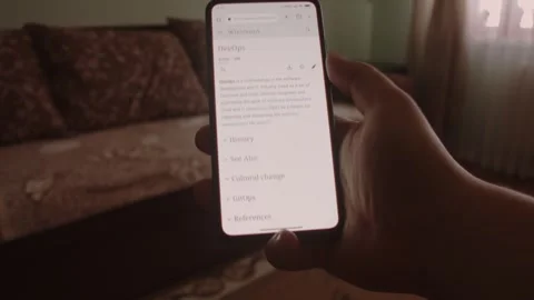 DevOps. Reading information about DevOps on mobile phone screen. 스톡 동영상 249819026