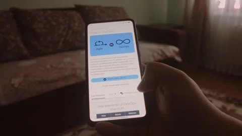 DevOps. Reading information about DevOps on mobile phone screen. Stock Footage 249819841