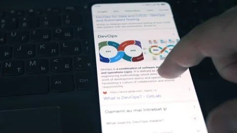 DevOps. Reading information about DevOps on mobile phone screen. Stock Footage 249819970