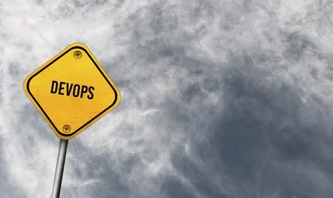 DevOps, yellow sign with cloudy sky Stock Photos