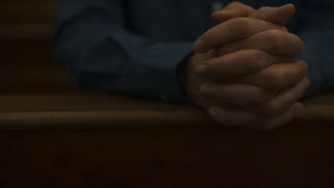 Devote Christian man praying in the Church with hands clasped Stock Footage 128518802